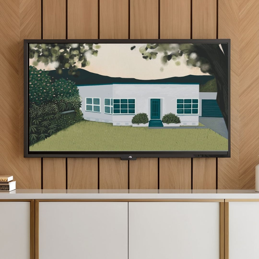 Framed artwork of a house on a wall above a white cabinet.